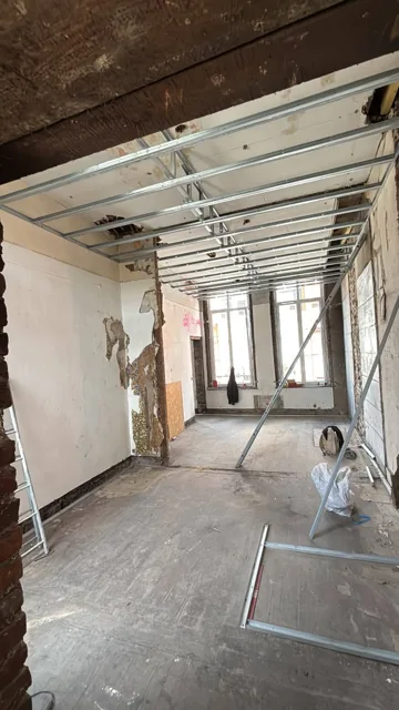 Ossature métallique de plafond en cours de pose dans une pièce en rénovation